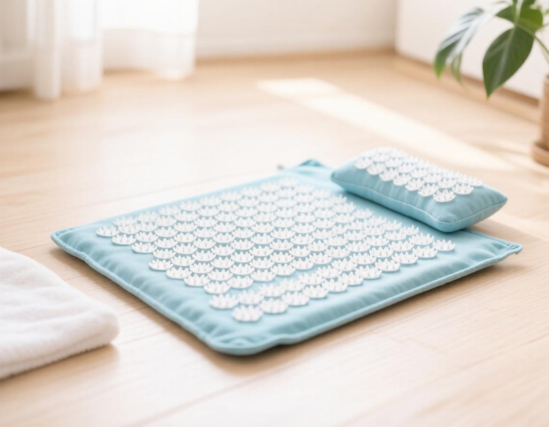 Light blue acupressure mat and neck pillow with white spike discs on a wooden floor