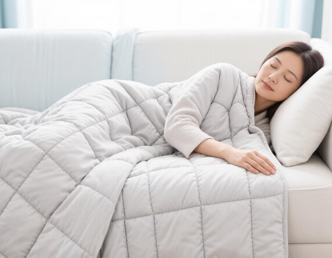 Woman sleeping peacefully on a sofa under a quilted weighted blanket